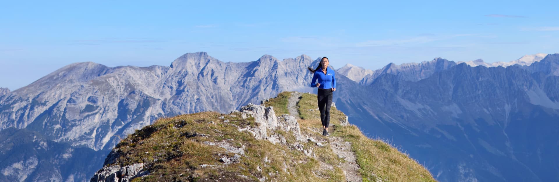 Scenic ridge training scene from Hannah Eden’s Austrian Alps hiking series on the iFIT fitness app, combining immersive alpine landscapes with structured endurance workouts.